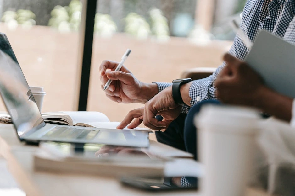 Человек делает пометки в блокноте во время деловой встречи